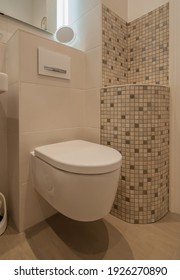 
Modern toilet facility with light brown tiles. In addition, a decoratively clad wall with mosaic