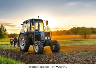 Modern tractor machinery plowing agricultural field meadow at farm at spring autumn during sunset.Farmer cultivating,make soil tillage before seeding plants,crops,nature countryside rural scene. - Powered by Shutterstock