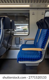 Modern train interior with empty seats and power sockets. Motion blur effect through the window.
