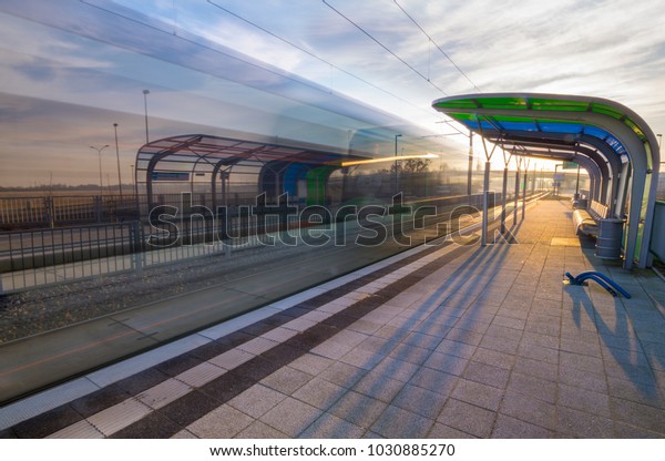 a\
modern tram stop, blurred silhouette of a passing\
tram