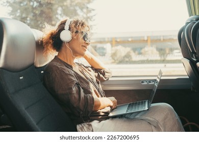 Moderno estilo de vida de viajes personas con una mujer sonriente feliz escuchando música con auriculares y computadora portátil sentados y relajándose en un asiento de autobús como pasajero de viaje. Mujeres en transporte