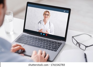 Modern treatment at home. Man watches at laptop with video woman doctor and gets consultation, close up, free space - Shutterstock ID 1761542783