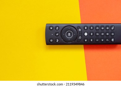 Modern Modern TV Remote Control On A Colored Background. Yellow And Orange. Flat Lay