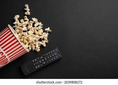 Modern Tv Remote Control And Popcorn On Black Background, Flat Lay. Space For Text