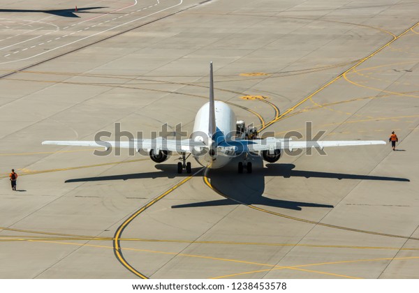 Modern twin engine civil airplane pushing back at\
international airport