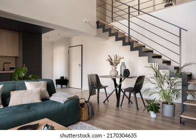Modern, two-floor apartment with stylish living room with dining table, open to kitchen and stairs to next floor