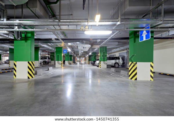 Modern underground\
parking garage with\
cars.