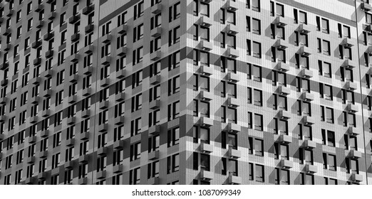 Modern urban background. Underside angle view of corner modern residential brick building with small windows frames and steel balcony in black and white tone.