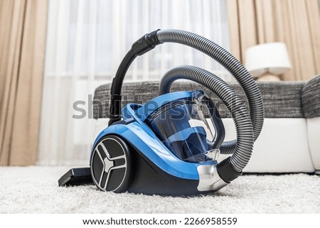 Modern vacuum cleaner in the living room. Vacuum cleaner on the background of the home interior.