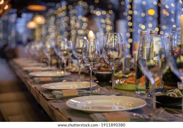Modern veranda restaurant interior, banquet\
setting, glasses, plates