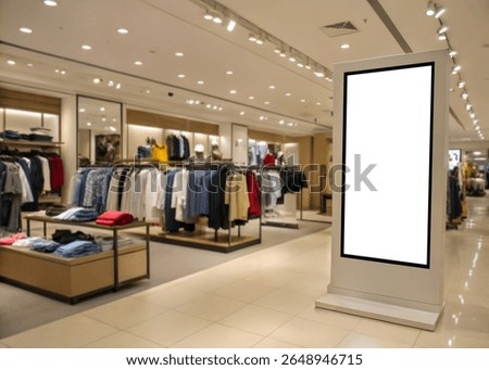 Modern vertical lightbox display inside a stylish clothing store, ideal for showcasing indoor advertisements or branding designs in retail environments.
