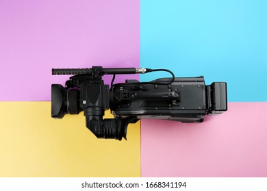 Modern Video Camera On Color Background, Top View