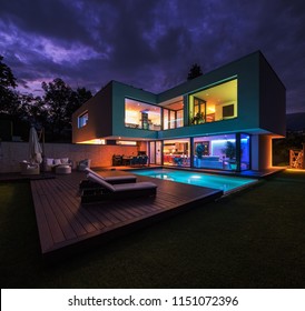 Moderne Villa mit farbenfrohen Lichtern am Abend. Niemand drinnen