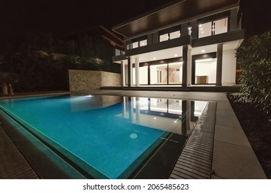 Modern Villa With Pool At Night. Home Real Estate Luxury Exterior With Led Lights. Nobody Inside.