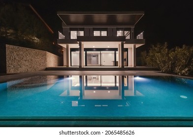 Modern Villa With Pool At Night. Home Real Estate Luxury Exterior With Led Lights. Nobody Inside.