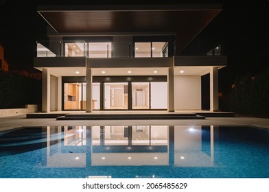 Modern Villa With Pool At Night. Home Real Estate Luxury Exterior With Led Lights. Nobody Inside.