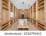 Modern walk-in closet with wooden shelves, elegant lighting, and a central island featuring a decorative plant.