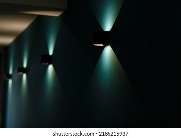 Modern wall lamps is lighting on the dark green wall. backlit, night decorative lamp