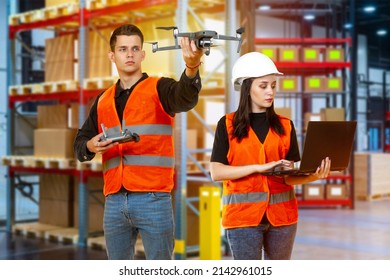 Modern warehouse technologies. Guy and girl are working in warehouse. Warehouse worker launches quadcopter. Use of quadcopter in logistics business. Logistics center employees with drone