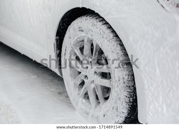 Modern washing of car wheels with foam and high\
water pressure. Car wash