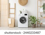 Modern washing machine with basket, shelving unit and ladder near white wall. Interior of home laundry room