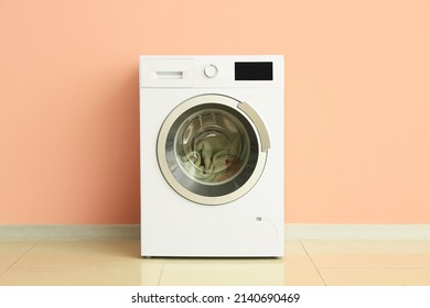 Modern Washing Machine With Laundry Near Wall