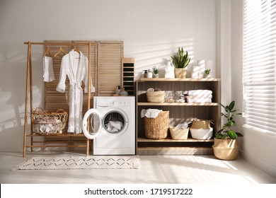 Modern washing machine and shelving unit in laundry room interior