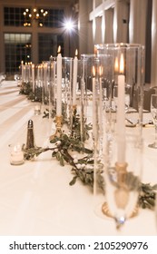 A Modern Wedding Venue With White Walls , Greenery, And Candles In Winter