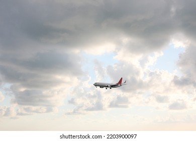 Modern white airplane flying in sky with clouds - Powered by Shutterstock