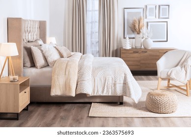 Modern White Bedroom Interior Featuring a Cozy Bed with Fluffy Warm Duvet and Set of Pillows, Facing a Wooden Dresser and a Window Illuminating the Space, blank Gallery Wall Mockup - Powered by Shutterstock