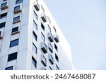 Modern white building with square windows. Multistory apartment building. Minimalistic Stylish living block of flats. Facades of modern office building. Exterior texture pattern