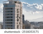 Modern white building towering over cityscape of Nicosia with Troodos mountains in background. Cyprus