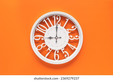 Modern white clock with a circle on a orange wall background, nine o'clock on the clock. Elegant clock, combination of white and orange colors - Powered by Shutterstock