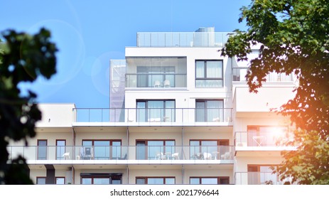 Modern white facade of a residential building with large windows. View of modern designed concrete apartment building. - Shutterstock ID 2021796644