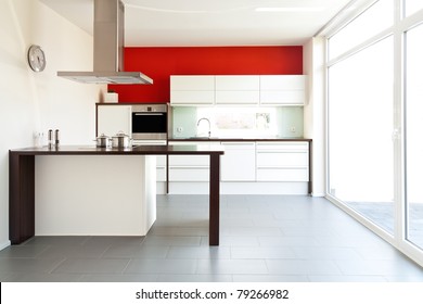 Modern White Kitchen With Red Wall In The Back