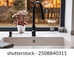 Modern White Kitchen Sink with black  Stainless Steel faucet, bright window with fall autumn season.