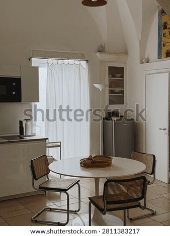 Modern White Kitchenette Design Featuring Cesca Style Chairs Circular Table And Stone Tile Flooring