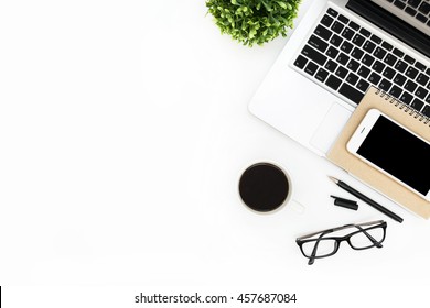 Современный белый офисный стол с ноутбуком, смартфон с черным экраном над ноутбуком и чашкой кофе. Вид сверху с копировальным пространством, плоский лежак.