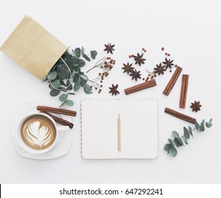 Modern White Office Desk Table With Cup Of Coffee. Blank Notebook Page For Input The Text In The Middle. Morning Composition. Top View, Flat Lay.