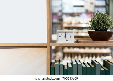 Modern white rectangle clock on the wood shelf with planting and books. Decoration concept.