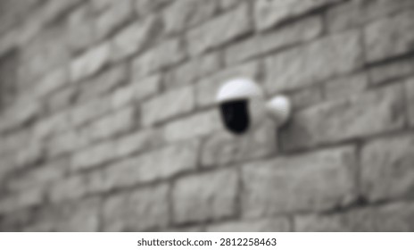 A modern white security camera is attached to a grey and beige textured brick wall, suggesting surveillance and protection.