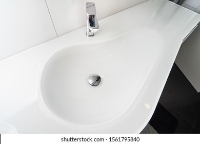 Modern white sink in the form of a drop in the bathroom.