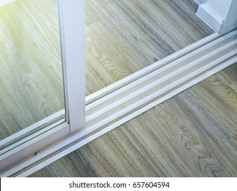 Modern White Sliding Glass Door With Rail On Wooden Floor.