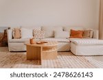 A modern white sofa with a selection of pastel colored pillows in a cozy small living room