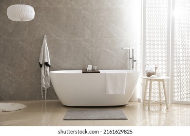 Modern White Tub And Table With Toiletries In Bathroom. Interior Design