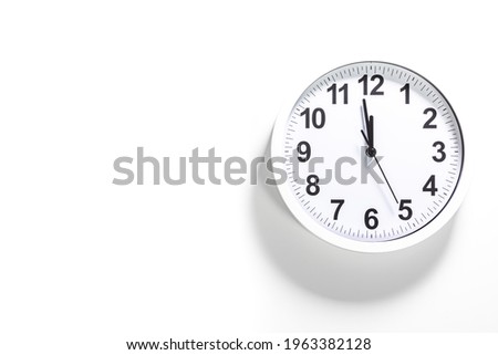 Modern white wall clock show the time. It's close to 12 o'clock. The latest report of the atomic scientist shows the doomsday clock 100 seconds to twelve.  Time is running out for mankind.