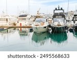 Modern white yachts in the seaport marina. Sea berth pier for mooring boats. Ships docked in port. Front view.