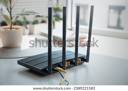 Modern wi-fi router on light table in room. High speed internet concept