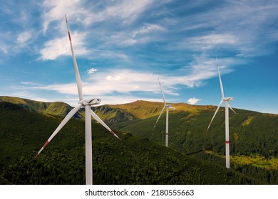 Modern wind turbines in mountains on sunny day. Alternative energy source