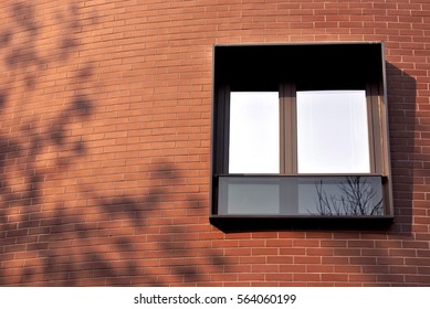 Modern Window And Tree Shadow On Red Brick Facade.